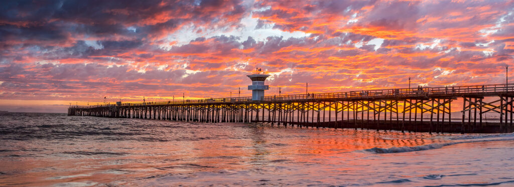 Seal Beach Pier at sunset with golden sky reflecting on the Pacific Ocean near Leisure World Seal Beach